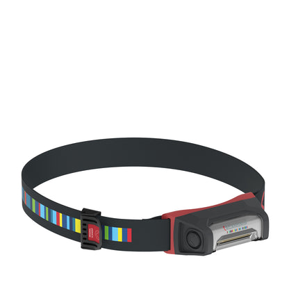 Scangrip headlamp featuring a black adjustable strap with vibrant vertical stripes in blue green yellow and red connected to a red and dark gray light unit displaying the Scangrip logo