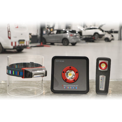 Three Scangrip professional LED work lights, including a headlamp with a colorful striped strap, a square CCT SCAN light with a red ring, and a rectangular inspection light, displayed in a blurred car workshop background with vehicles on lifts