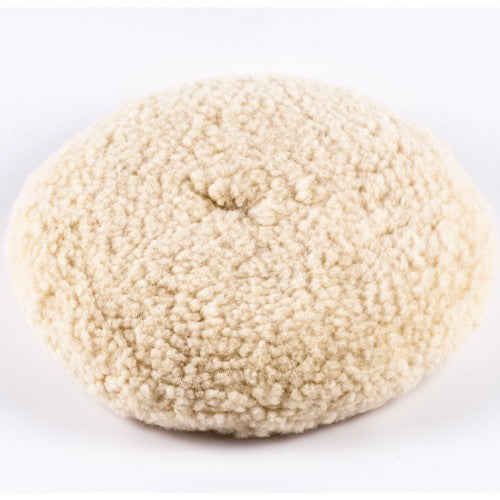 Circular cream colored wool buffing pad with a dense shaggy texture on a clean white background