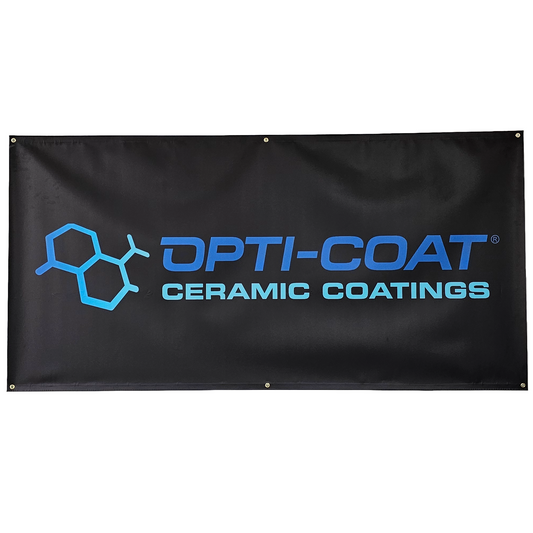 Black vinyl banner displaying the OPTI-COAT CERAMIC COATINGS logo with a blue molecular graphic and bright blue text, accented by metal grommets for hanging