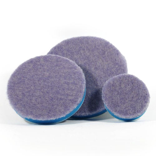 Product photography of three varying sized circular purple wool polishing pads with blue foam backing on a clean white studio background