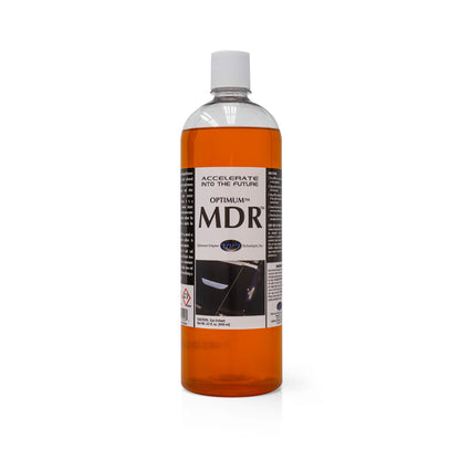 Product photography of an Optimum MDR car care product bottle containing bright orange liquid, with a white cap, the slogan Accelerate Into The Future, and a glossy car panel graphic on its label against a white studio background