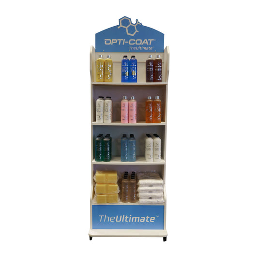 Product photograph of an Opti-Coat TheUltimate brand display stand on a white background featuring a blue header with a chemical structure logo shelves filled with colorful yellow blue pink orange green and white product bottles and a bottom shelf holding yellow wax bars and white bundled cloths