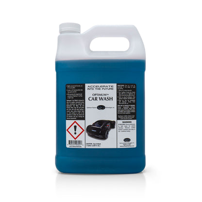 Product Photography of a one-gallon white plastic jug of Optimum Car Wash containing dark blue liquid, featuring a label with "ACCELERATE INTO THE FUTURE" text, a futuristic black sports car illustration, and a prominent red eye irritant warning symbol