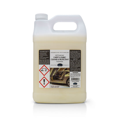 Digital photograph of a white one-gallon jug of Optimum Carpet & Fabric Cleaner & Protectant Concentrate, featuring a detailed black label with a luxurious beige car interior, two prominent red chemical hazard symbols, and text indicating "CAUTION: Eye Irritant"