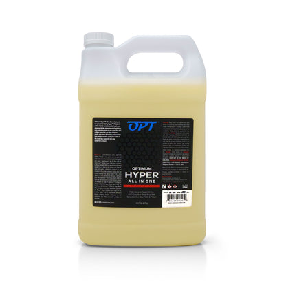 Product photography of a translucent white gallon jug of Optimum Hyper All In One car care product filled with yellow liquid, featuring a black and blue label detailing it as a Polish Ceramic Sealant & Wax in a 128 fl oz container with a white ribbed cap and integrated handle on a white background