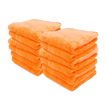 A product photograph showing two neat stacks of bright orange fluffy microfiber cleaning towels