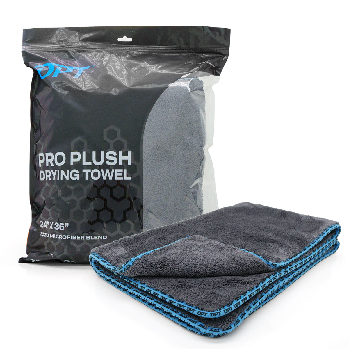 Product photography of an OPT Pro Plush Drying Towel, a dark grey microfiber towel with vibrant blue branded trim folded beside its black plastic packaging displaying a honeycomb pattern and descriptive text on a clean white background