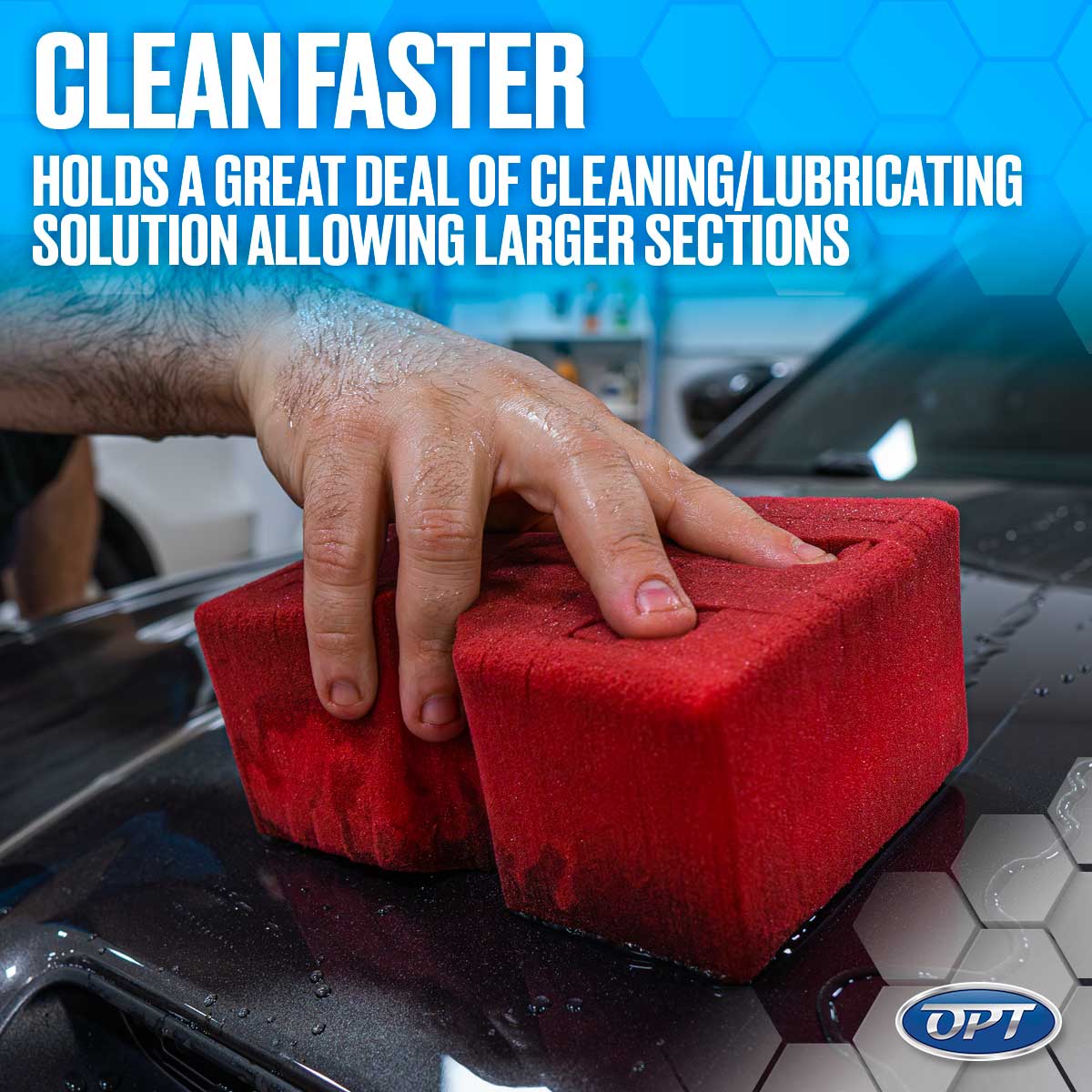 Photograph of a wet hand firmly pressing a bright red rectangular cleaning sponge onto a dark metallic grey car surface speckled with water droplets inside what appears to be a car detailing bay, with a blue hexagonal background displaying bold white text "CLEAN FASTER"