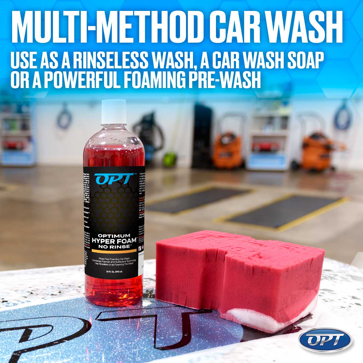 A transparent bottle of OPT Optimum Hyper Foam No Rinse car wash containing bright red liquid with a black and blue label is displayed next to a bright pink car wash sponge showing white residue on a sparkling blue surface in a car wash bay, highlighted by the text "MULTI-METHOD CAR WASH USE AS A RINSELESS WASH, A CAR WASH SOAP OR A POWERFUL FOAMING PRE-WASH"