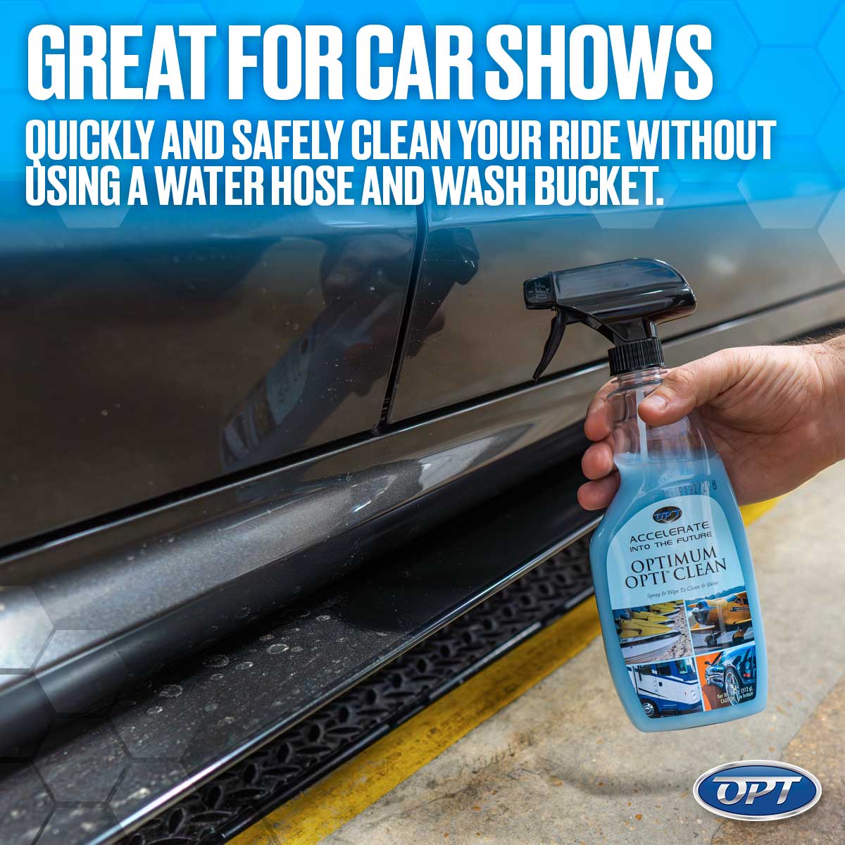 Digital photograph shows a hand holding a blue Optimum Opti-Clean spray bottle against a dirty dark grey car's lower panel and textured running board, positioned on asphalt next to a yellow curb line, with promotional text "GREAT FOR CAR SHOWS QUICKLY AND SAFELY CLEAN YOUR RIDE WITHOUT USING A WATER HOSE AND WASH BUCKET" overlaid