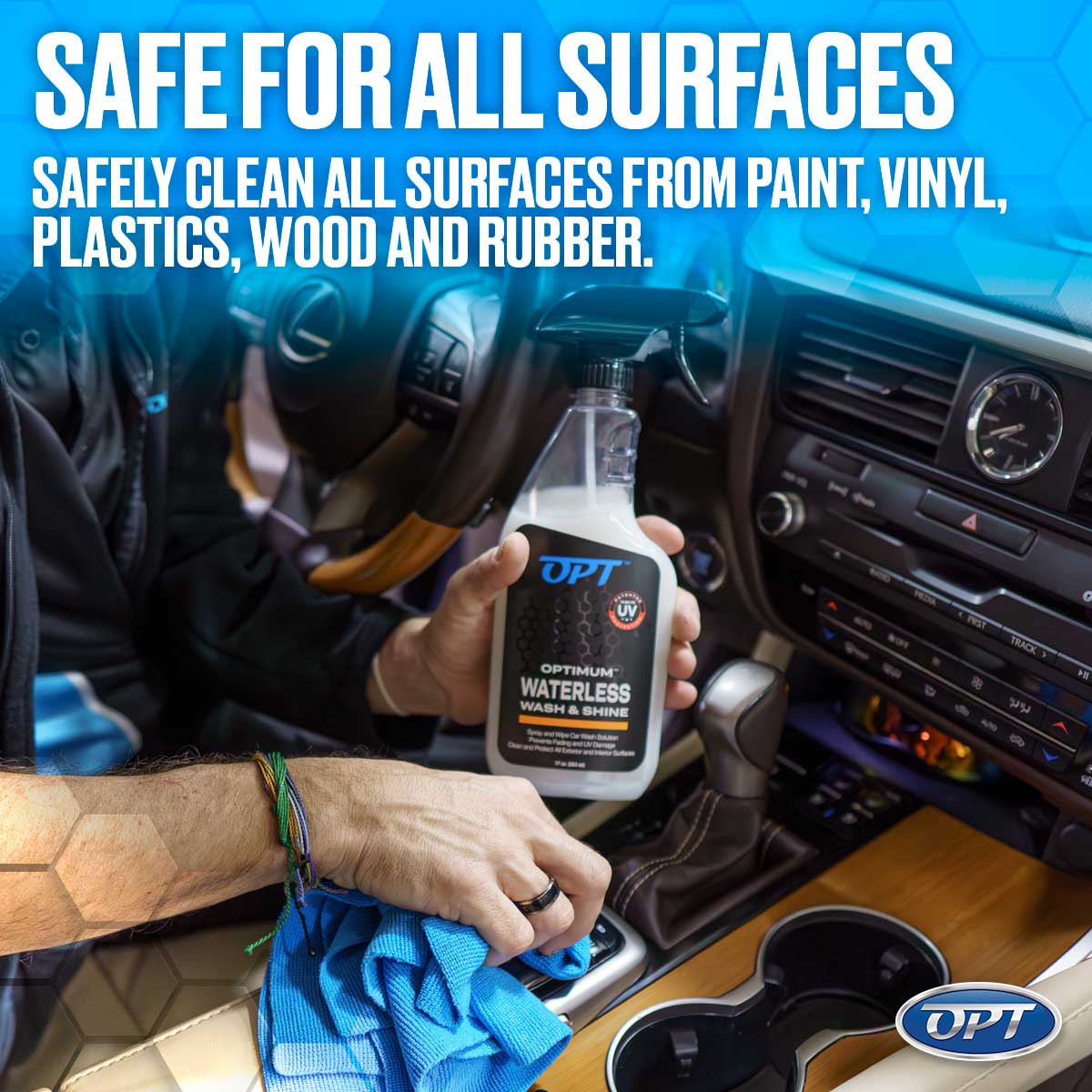 A person holds an Optimum Waterless Wash & Shine spray bottle and blue microfiber cloth, cleaning a car interior with a Lexus steering wheel dashboard and wood trim, advertised as safe for all surfaces