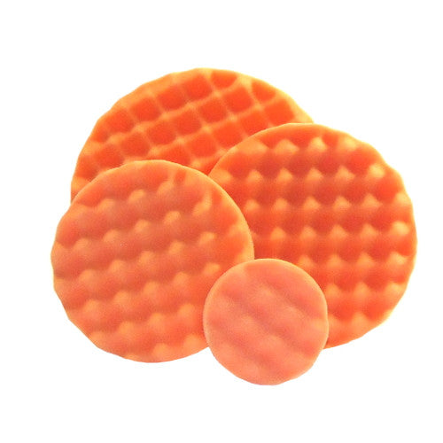 Four overlapping round orange discs with textured surfaces, three featuring a prominent waffle pattern and one with a subtle wavy design against a white background