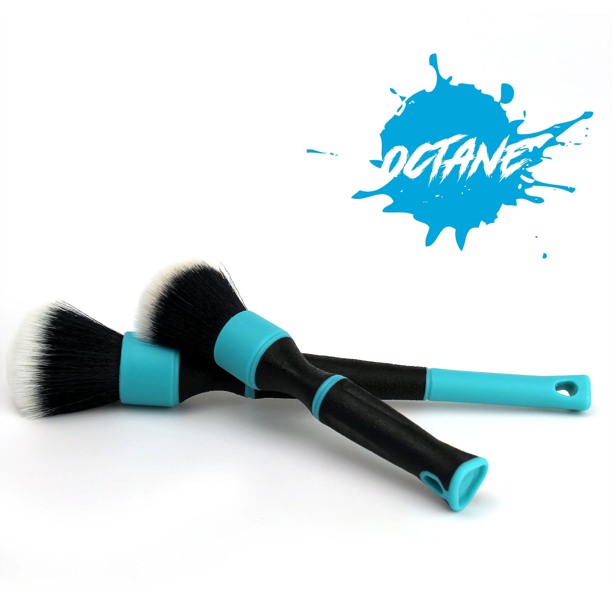 Two car detailing brushes with black bristles, white tips, black handles, and bright turquoise accents on a white background featuring a blue Octane splash logo