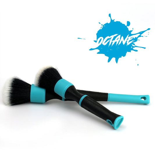 Two car detailing brushes with black bristles, white tips, black handles, and bright turquoise accents on a white background featuring a blue Octane splash logo