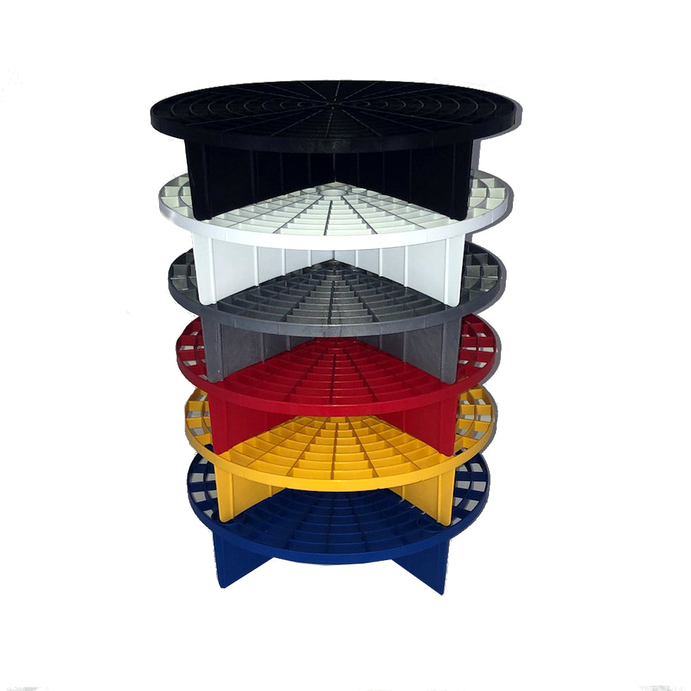 Plastic, a stack of six modular circular risers in black white gray red yellow and blue, each with a distinctive gridded conical interior, presented against a clean white background
