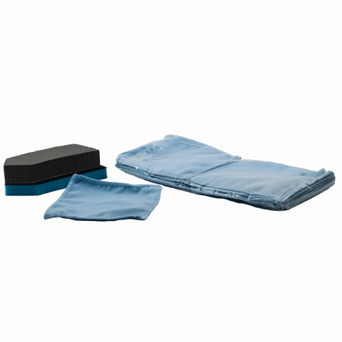 Photograph of cleaning accessories featuring a stack of individually wrapped pale blue microfiber cloths a single unfolded blue cloth and two black sponge applicators with blue bases on a white background