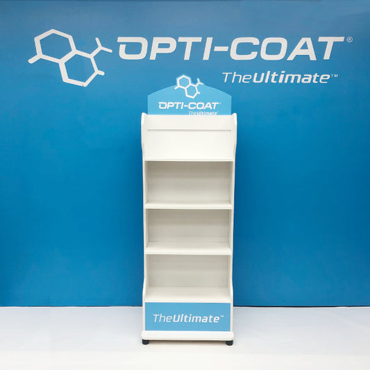 Product photography of an empty white OPTI-COAT The Ultimate four-shelf retail display rack set against a vibrant blue wall with the brand's chemical structure logo